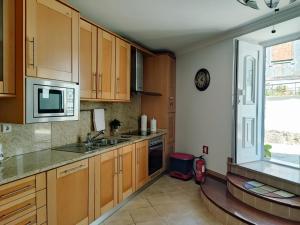 a kitchen with wooden cabinets and a sink and a window at Casinha do Sossego in Melgaço