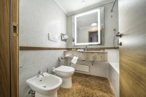 a bathroom with a toilet and a sink and a mirror at Hilton Milan in Milan