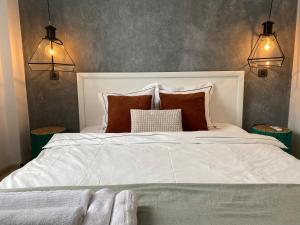 a bedroom with a large white bed with pillows at Old Town Overlooking - Vibrant 2BR Apartment in Bucharest