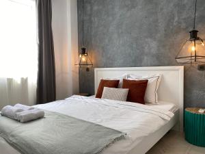 a bedroom with a large white bed with pillows at Old Town Overlooking - Vibrant 2BR Apartment in Bucharest