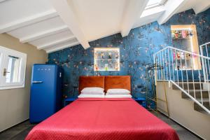 a bedroom with a red bed and a blue wall at ALTANA HOUSE TORTELLINOSUITE Modena in Modena