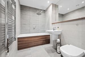 uma casa de banho com um WC, um lavatório e uma banheira em One Cambridge Residence by COQOON em Manchester