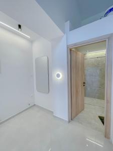a white room with a door and a walk in shower at Oasis Acropolis Serres Next to Center in Serres