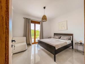 a bedroom with a bed and a chair and a window at Oasis Acropolis Serres Next to Center in Serres