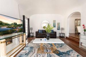 a living room with a large tv on a wall at Serenity in the City: 2BR Apartment w/ Hot Tub in Los Angeles