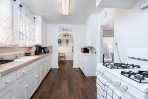 a kitchen with white cabinets and a stove top oven at Serenity in the City: 2BR Apartment w/ Hot Tub in Los Angeles