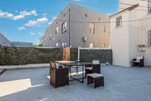 a patio with a table and chairs in front of a building at Serenity in the City: 2BR Apartment w/ Hot Tub in Los Angeles