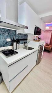 a white kitchen with a sink and a stove at Deluxe Dream - Azure North in Maimpis