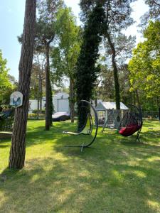 a park with a swing set and trees at Aqua Marine in Jurata
