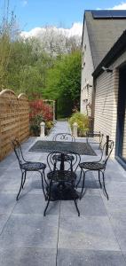 a table and two benches on a patio at Le Loft du Renard, gîte cosy au coeur de la nature boisée à Namur Wépion, une parenthèse douce dans la vallée mosane in Namur