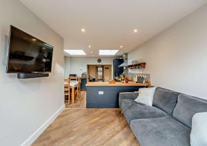 a living room with a couch and a kitchen at Fern Lea in Brancaster
