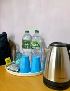 2 Flaschen Wasser und ein Wasserkocher auf dem Tisch in der Unterkunft Private double room near Metro 5 in Bobigny