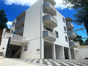 a white building with balconies on the side of it at Apartmani Marija in Duće