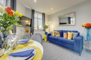 a living room with a blue couch and a table at Coventry 2 Bedroom Apartment, Sleeps 4, Parking in Wyken