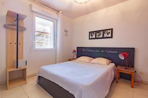 um quarto com uma cama grande e uma janela em Le Jouarres - Appt climatisé avec piscine partagée em Azille
