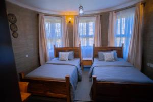 two beds in a room with two windows at Boloti Camp resort in Lemira