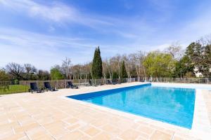 uma piscina com água azul num quintal em Le Jouarres - Appt climatisé avec piscine partagée em Azille