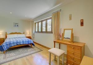 ein Schlafzimmer mit einem Bett, einem Spiegel und einer Kommode in der Unterkunft Ruston Lodge in Thursford