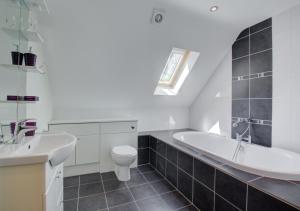ein Badezimmer mit einer Badewanne, einem WC und einem Waschbecken in der Unterkunft Ruston Lodge in Thursford