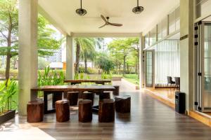 a dining room with wooden tables and stools at The Q Residence Vientiane in Vientiane