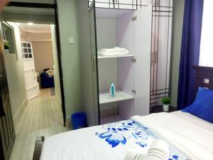 Schlafzimmer mit einem weißen Bett und einem Spiegel in der Unterkunft Emerald Gardens Airbnb in Kitale