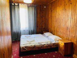 ein Schlafzimmer mit einem Bett in einer Holzwand in der Unterkunft Green House in Wola Przypkowska