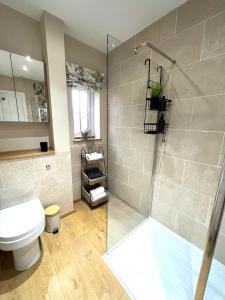 a bathroom with a shower stall and a toilet at Olive Holiday Cottage Matlock in Matlock Bank +41 photos