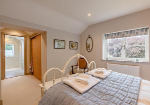 een slaapkamer met een bed met twee handdoeken erop bij Alcocks Cottage in Syderstone