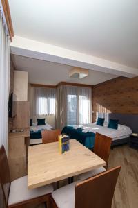 um quarto com duas camas e uma mesa e cadeiras em Central Inn em Zlatibor