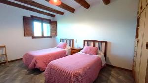 - 2 lits dans une chambre avec des draps roses dans l'établissement Casa Miret de Mur, à Vilamolat de Mur