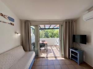 a bedroom with a bed and a television and a table at Charmant appartement Village Restanques de Saint Tropez in Grimaud