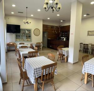 a restaurant with tables and chairs and a kitchen at Via Ferrata Hotel in Prousós
