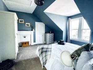 a blue bedroom with a white bed and a window at Charming 3-bedroom maisonnette in Inverness City Centre in Inverness