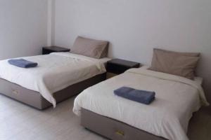 two beds sitting next to each other in a room at By The Sea Deluxe Condo @ Batu Ferringhi Penang in Batu Ferringhi