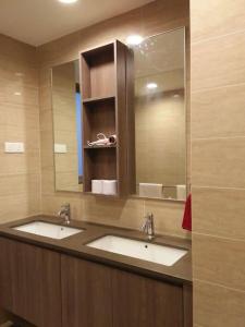 a bathroom with two sinks and a large mirror at By The Sea Deluxe Condo @ Batu Ferringhi Penang in Batu Ferringhi +36 photos