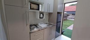 eine kleine Küche mit einer Spüle und einer Arbeitsplatte in der Unterkunft Hub Accomodation in Kimberley
