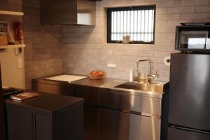 a kitchen with a sink and a stainless steel refrigerator at 三間屋 mitsumaya in Kanazawa