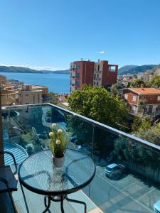 a glass table on a balcony with a view of the water at Vanja Apartment with Private Parking - Sea View in Pržno