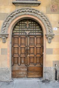 a large wooden door on the side of a building at ITALIA HOUSE TORTELLINOSUITE Modena in Modena