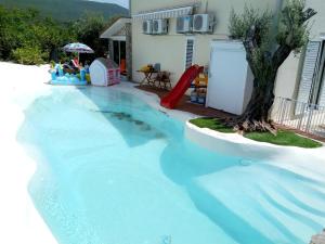a swimming pool with a slide in a house at Suntime villa Laguna in Bigova