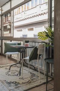 グラナダにあるtuGuest Duquesa Apartmentのテーブルと椅子、窓が備わる客室です。