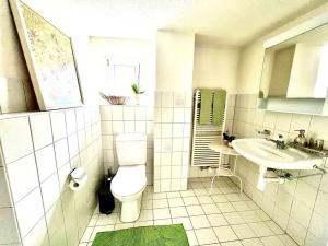 Ennenda的住宿－Apartment Glärnisch，白色的浴室设有卫生间和水槽。