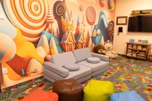 a living room with a couch and a disney mural at Bellamonte Aparthotel in Zakopane