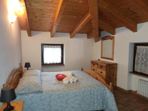 een slaapkamer met een bed met een knuffeldier erop bij Mansarda Dolomitica in Ronzo Chienis