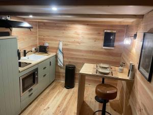 a small kitchen with a table and a sink at Cabane bien belge avec cinéma et jacuzzi in Lasne