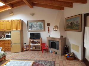 a living room with a fireplace and a kitchen at Mansarda Dolomitica in Ronzo Chienis