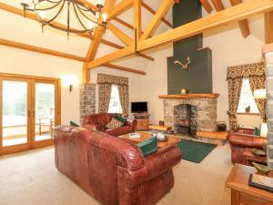 a living room with leather furniture and a fireplace at Glen View in Dumfries