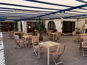 an outdoor patio with tables and chairs and a blue ceiling at Hotel Blason Junior in Peniscola