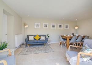 a living room with a blue couch and a table at Orchard Barn in Wighton