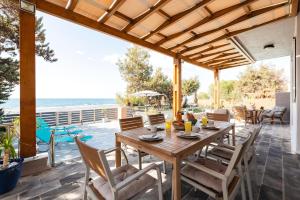 patio ze stołem i krzesłami oraz widokiem na ocean w obiekcie Villa Perla w mieście Lardos